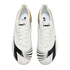 Top-down view of white Diadora soccer cleats with black graphic patterns on the toes and gold and silver accents on the heels, against a black background.