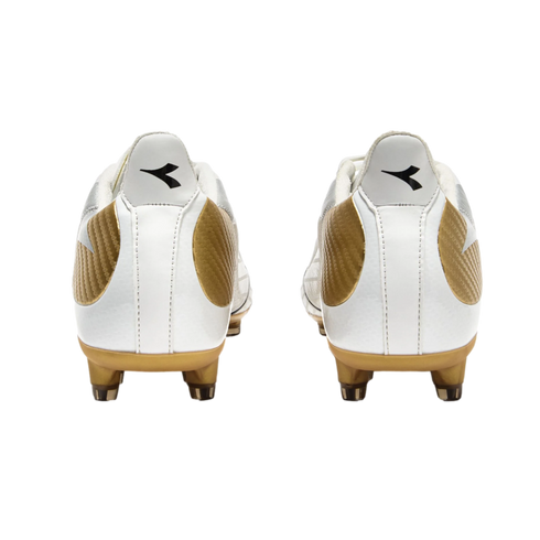 Rear view of two white and gold Diadora soccer cleats with black logos on the heels, set against a black background.