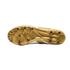 Bottom view of a white and gold soccer cleat featuring a metallic gold sole plate and circular studs, set against a solid black background.