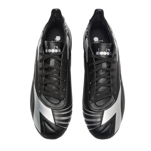 Top-down view of black Diadora soccer cleats featuring silver accents and branding, isolated on a black background.