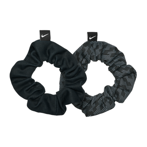 Two Nike hair scrunchies on a black background. One is solid black and the other has a dark grey patterned design. Both feature a small tag with a white swoosh logo.