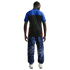 Back view of a man in a blue and black t-shirt and blue marbled print trousers with white sneakers, against a solid black background.