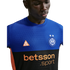 A man wearing a blue and black Inter Milan soccer jersey with orange ACG and Betsson Sport logos against a black background.