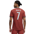 Back view of a man wearing a red Portugal jersey with "RONALDO" and "7" on the back. He has dark braided hair and is set against a black background.