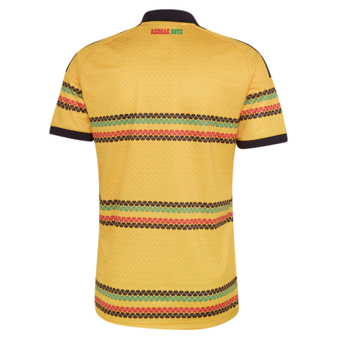 Back view of a yellow Jamaica football jersey with horizontal red, green, and black patterned stripes and "REGGAE BOYZ" text on the upper back. Black collar and sleeve trim.