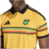 Close-up of a person wearing a yellow Adidas Jamaica national football team jersey with a black collar and colorful horizontal patterns.