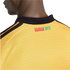 Close-up of the back of a yellow jersey with black stripes on the shoulders and "REGGAE BOYZ" printed in red and green below a black collar.