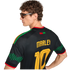 A man in sunglasses seen from behind, wearing a black "MARLEY 10" Reggae Boyz jersey with green zigzag patterns on the sleeves.