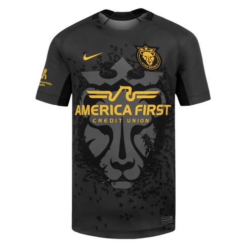 A black and gold Utah Royals soccer jersey by Nike, featuring a large lion head graphic with small bee patterns and the "America First Credit Union" sponsor logo.