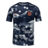 Nike short-sleeve athletic top with a navy and grey rocky camo print, white polka dots, an orange swoosh, and a circular "FB" crest on the chest.