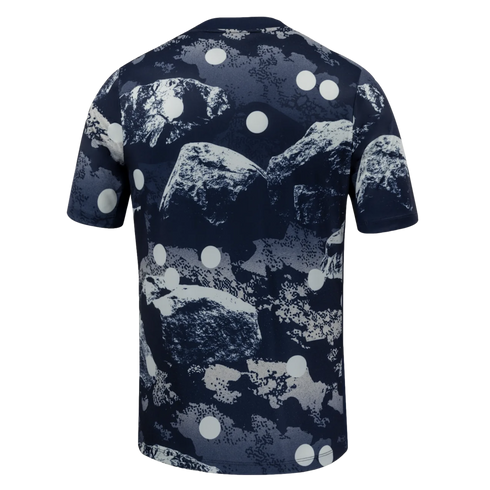 Rear view of a dark blue short-sleeved t-shirt featuring an abstract grey and white rock formation print with white polka dots.