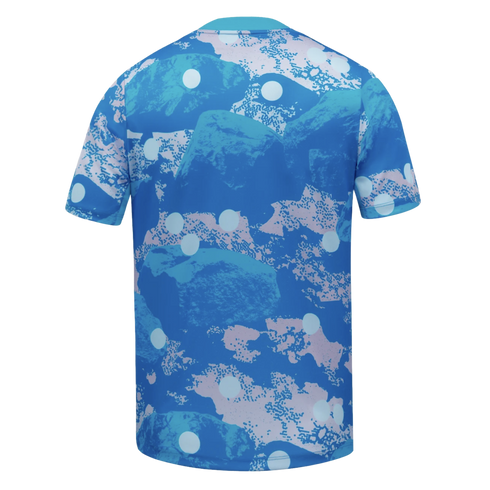 Back of a short-sleeved t-shirt featuring an abstract blue and pink rock camouflage pattern with scattered white polka dots.
