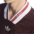 Close-up of a black Adidas jersey featuring a red repeating "AFC" pattern and a white V-neck collar with red stripes and "P+AFC" embroidery.