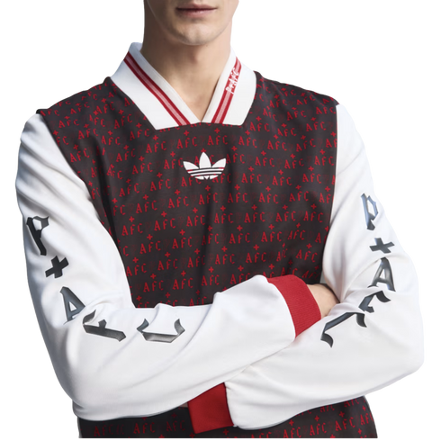 Man wearing an Adidas long-sleeve jersey with a dark, patterned 'AFC' torso, white sleeves featuring gothic 'P+AFC' text, red cuffs, and a striped V-neck collar.