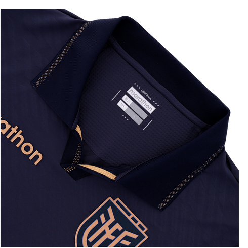 A close-up of the collar and upper chest of a navy blue sports jersey. It features a polo collar with copper-gold dotted trim, the "marathon" brand name on the chest and an inner tag, and a portion of a geometric crest at the bottom.