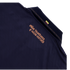 A close-up of the back collar area of a dark navy blue shirt. Below the collar, a Spanish slogan is printed in a stylized copper-colored font that reads "SOÑAR, TRASCENDER Y HACER HISTORIA." A small Colombian flag is visible on the ribbed collar, and the
