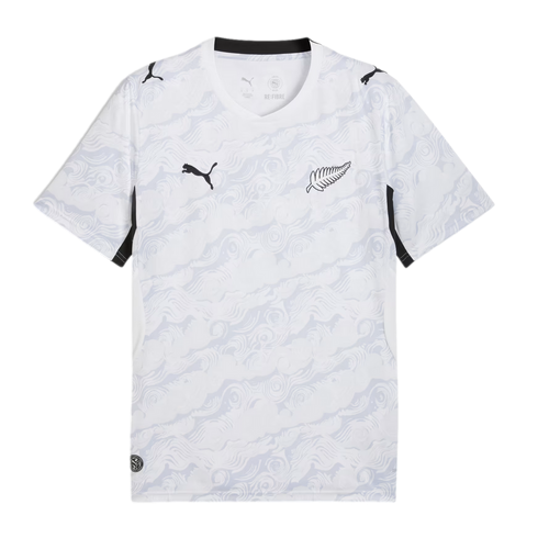 A white Puma short-sleeve soccer jersey featuring an all-over light grey abstract swirling pattern. It displays a black Puma logo on the right chest, a silver fern emblem on the left, and black accents on the collar and sleeve panels.