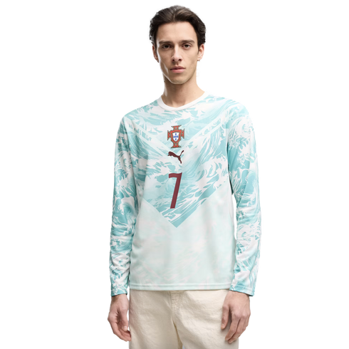 A young man stands against a black background wearing a light blue and white wavy-patterned long-sleeved shirt. The shirt features the Portugal national team crest, a brown Puma logo, and a large brown number 7 on the front.