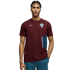 A young man with braided hair models a maroon Puma short-sleeve shirt featuring the Portugal national team crest and a teal side pocket detail, set against a solid black background.