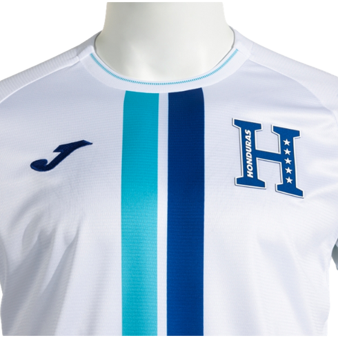 Close-up of a white Joma Honduras national team jersey with central turquoise and navy blue vertical stripes and a large blue 'H' emblem featuring five stars and the word "HONDURAS."