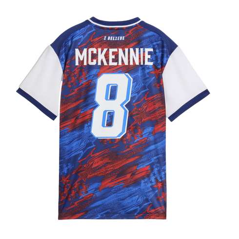 The back of a blue, red, and white patterned soccer jersey featuring the name "MCKENNIE" and the number 8.