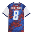 The back of a blue, red, and white patterned soccer jersey featuring the name "MCKENNIE" and the number 8.