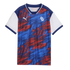 A short-sleeved Puma soccer jersey with a patriotic red, white, and blue theme. The main body of the shirt features an energetic, abstract pattern of blue and red brushstrokes and stars on a navy background. The jersey has a navy blue V-neck collar with w