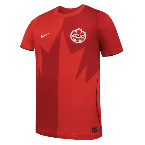 A red Nike Canada soccer jersey featuring a two-tone split design and a large stylized maple leaf graphic across the front.