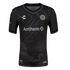 A black short-sleeved soccer jersey featuring a large, subtle grey dragon illustration across the front. The jersey includes the colorful Oakland Roots SC crest on the chest, a white Anthem sponsor logo in the center, and a repeating grey scale pattern on