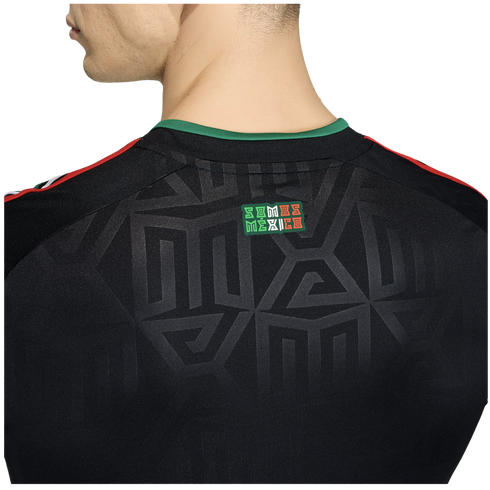 Close-up of the back of a black jersey featuring a green collar, tonal geometric patterns, and a small "SOMOS MÉXICO" patch.