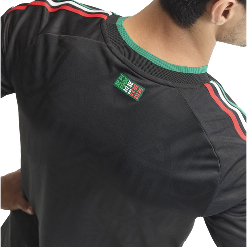 Back view of a black sports jersey with green, white, and red stripes on the shoulders and a "SOMOS MÉXICO" patch at the neck.
