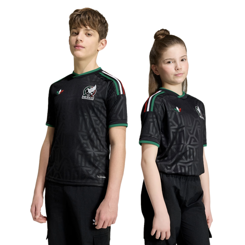 A boy and girl stand side-by-side wearing matching black Mexico national soccer team jerseys with green trim and geometric patterns against a white background.