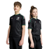 A boy and girl stand side-by-side wearing matching black Mexico national soccer team jerseys with green trim and geometric patterns against a white background.