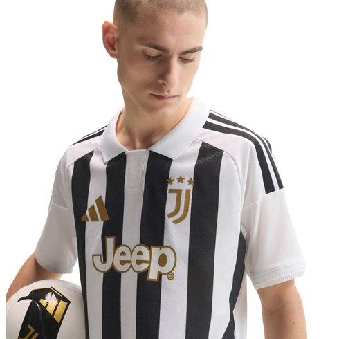 A man wearing a black and white striped Juventus soccer jersey with gold accents, holding a soccer ball against a white background.