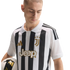 A man wearing a black and white striped Juventus soccer jersey with gold accents, holding a soccer ball against a white background.