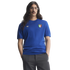 A man with long dark hair, glasses, and a mustache wearing a blue Adidas Italia knit shirt and grey trousers against a white background.