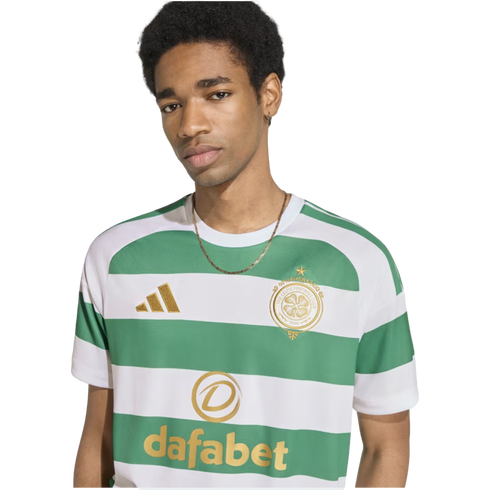 A young man wearing a green and white striped Celtic FC soccer jersey with gold Adidas and Dafabet logos, set against a plain white background.