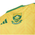 Close-up of a yellow South Africa sports jersey with a green embroidered crest featuring a King Protea flower and "SOUTH AFRICA" text.