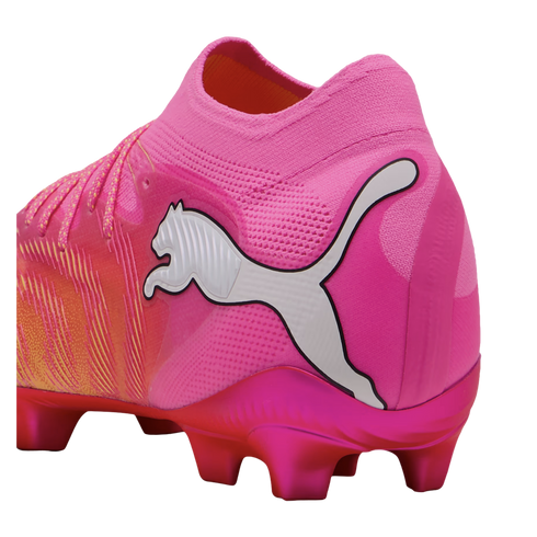 Vibrant pink Puma soccer cleat featuring a white logo, metallic magenta studs, and an orange-to-pink gradient textured upper.