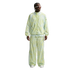 A person wearing a pale green patterned Nike tracksuit with wide-leg pants, white sunglasses, and white sneakers against a white background.