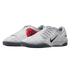 A pair of light grey Nike Total 90 indoor soccer shoes featuring a distinctive red "90" circular logo and a black Nike Swoosh.