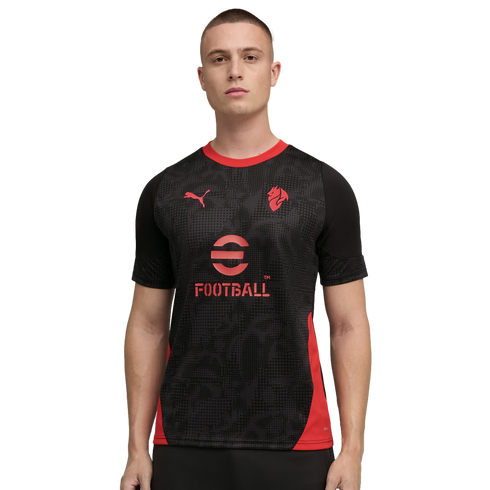 A man modeling a black Puma soccer jersey with red accents and the eFootball logo on a black background.