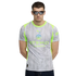 A man in dark sunglasses stands against a black background wearing a grey and lime green Manchester City jersey with a water droplet pattern.