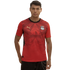 A man wearing a red Egypt national football team home jersey by Puma, featuring subtle geometric patterns and the team crest, standing against a plain black background.