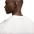 A close-up profile view from the back of a man wearing a white Puma jersey featuring mint green and orange patterned shoulders and a small Ivory Coast flag on the back collar.