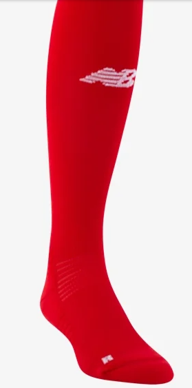 Long red athletic sock featuring a white New Balance logo on the upper shin and textured ribbing at the ankle, shown against a plain white background.