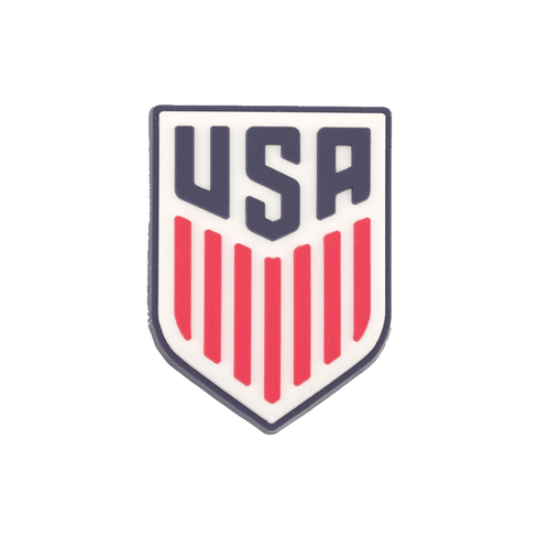Shield-shaped crest with dark blue "USA" block lettering above seven vertical red stripes on a white background.