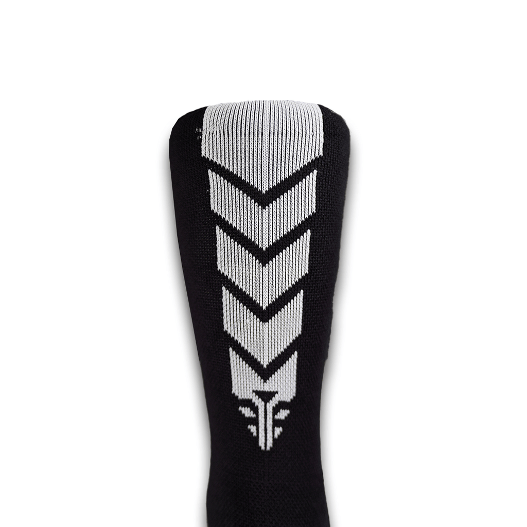 A close-up view of the For The Footballer XLR8R Pro No Slip Socks - Black, featuring a bold white vertical chevron pattern on the back of the calf.