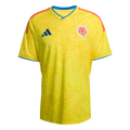 Yellow Adidas Colombia national team soccer jersey with a subtle tonal butterfly pattern, blue collar and sleeve trim, and orange shoulder stripes.