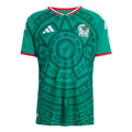A green Mexico soccer jersey with an intricate dark green Aztec-style pattern, white Adidas logo, Mexico crest, and red and white trim on the collar and sleeves.